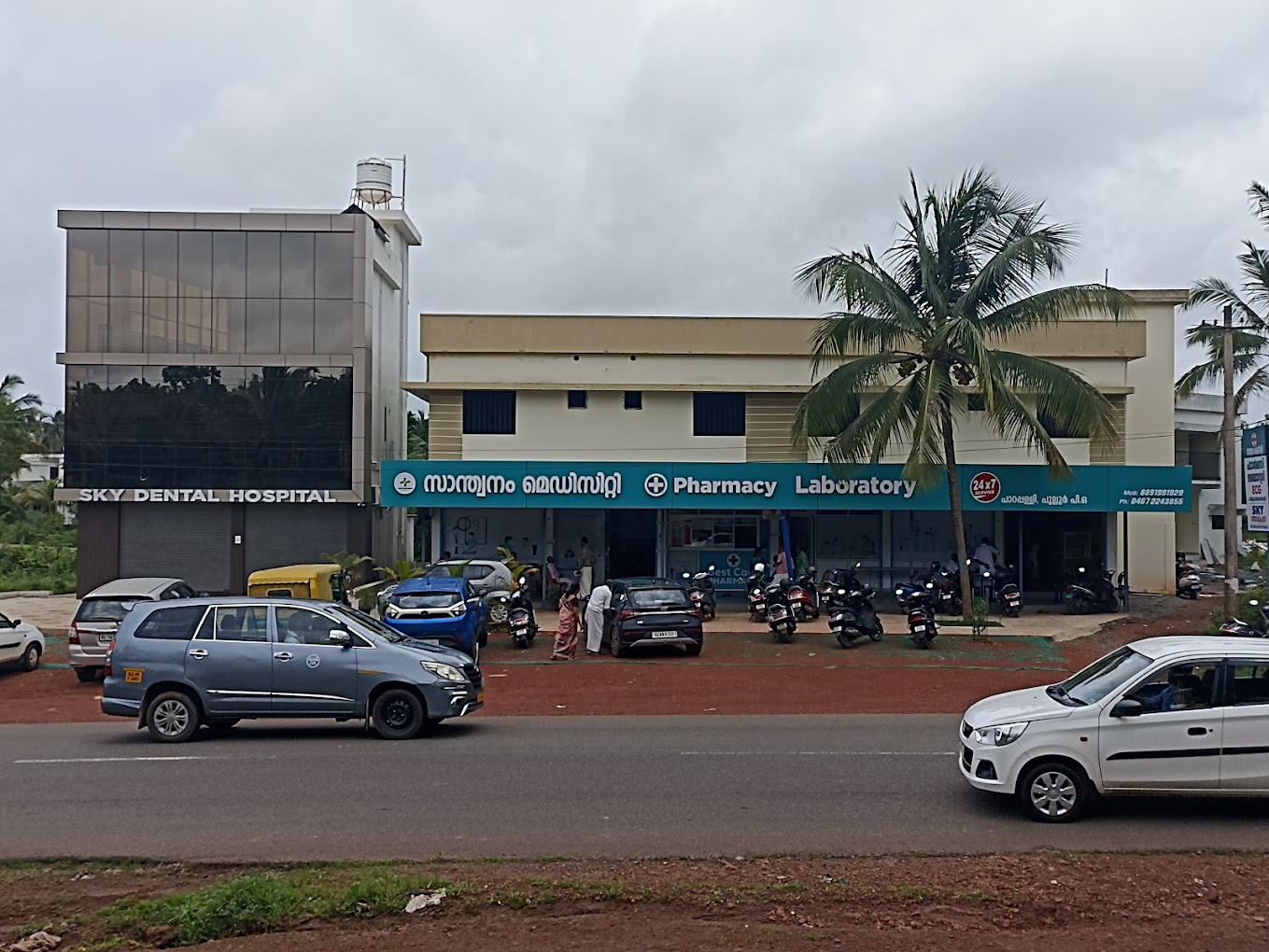 Santhwanam Medicity from the main road in Parapally — its teal 24×7 Pharmacy and Laboratory signage, beside Sky Dental Hospital.
